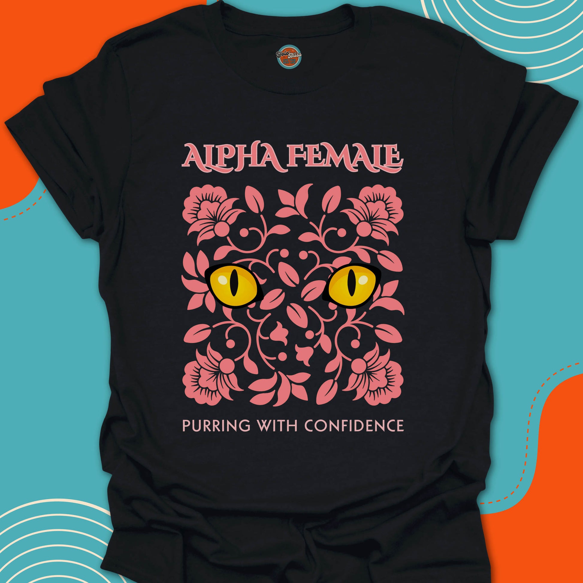 Black t-shirt with pink floral design and yellow cat eyes graphic along with "alpha female purring with confidence" text