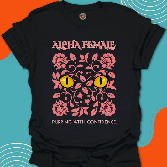 Black t-shirt with pink floral design and yellow cat eyes graphic along with "alpha female purring with confidence" text