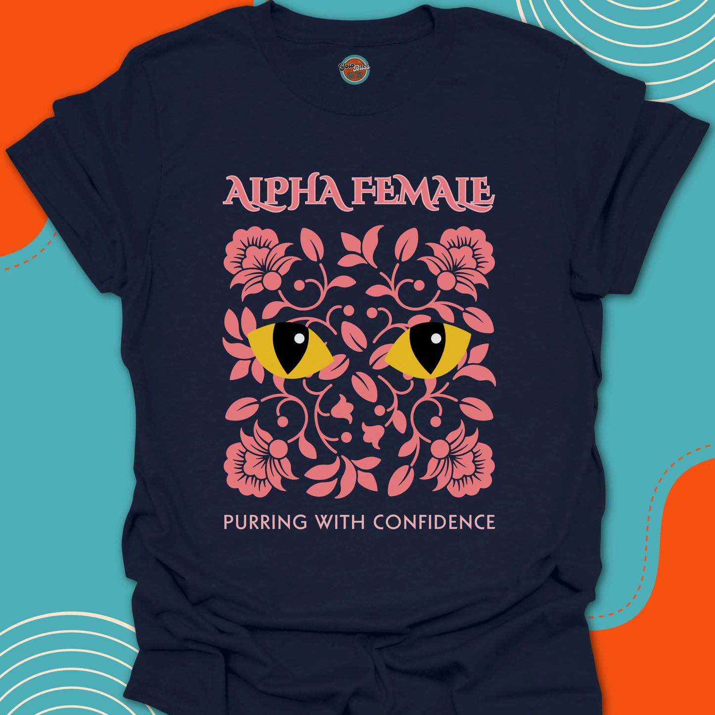 Navy t-shirt with pink floral design and rounded yellow cat eyes graphic along with "alpha female purring with confidence" text