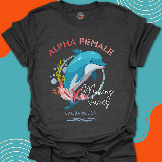 Dark gray t-shirt with a jumping dolphin graphic and "alpha female, making waves everywhere i go" text on an oceanic background