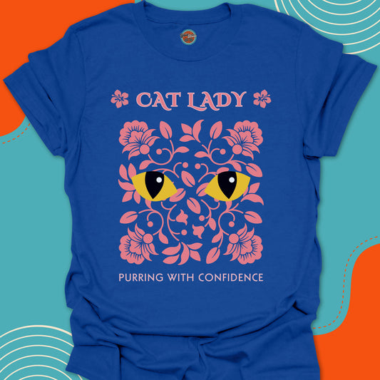 Fashionable Royal Blue t-shirt with pink floral design and rounded yellow cat eyes graphic along with "Cat Lady, purring with confidence" text