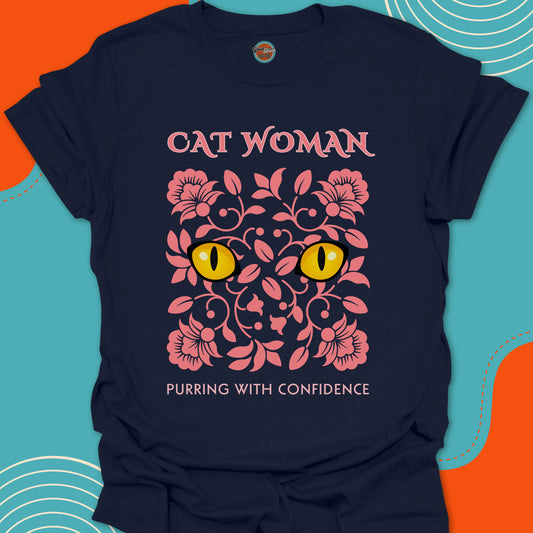 Navy blue t-shirt with pink floral design and yellow cat eyes graphic along with "Cat Woman, purring with confidence" text