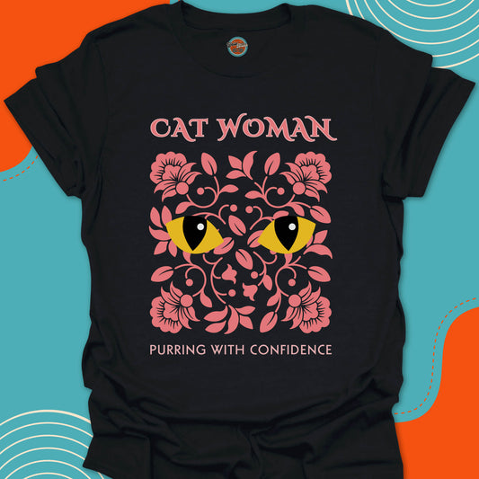 Black t-shirt with pink floral design and stylish yellow cat eyes graphic along with "Cat Woman, purring with confidence" text