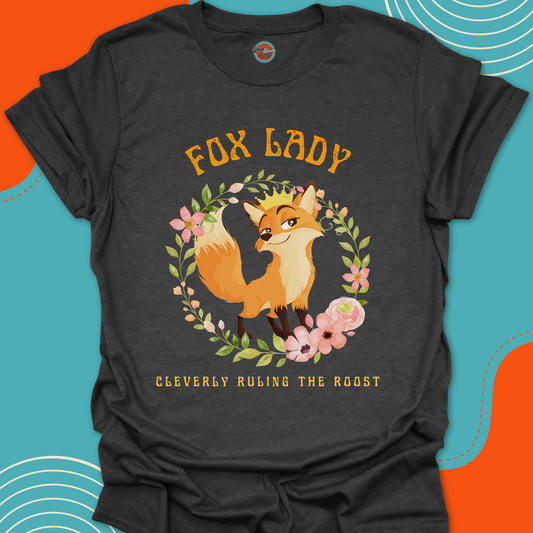 Dark gray t-shirt with a cute fox wearing a golden crown on her head and floral circular arrangement graphic and "Fox Lady, cleverly ruling the roost" text