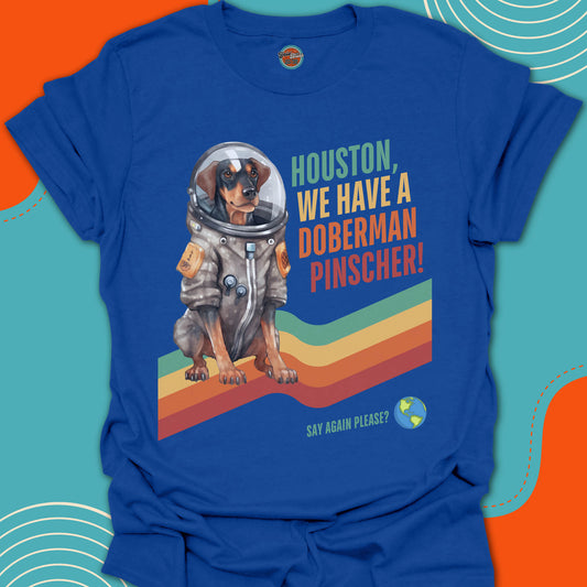 Blue t-shirt with a doberman pinscher in an astronaut suit graphic and text on a colorful background