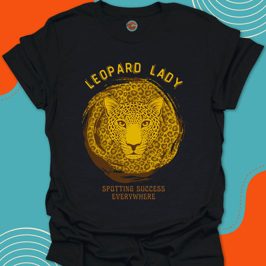 Black t-shirt with a gold leopard graphic and "Leopard Lady, spotting success everywhere" text