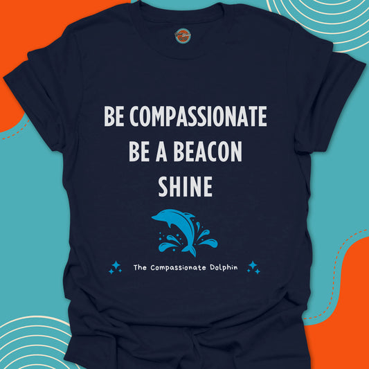Navy blue t-shirt with motivational text "Be compassionate, be a beacon, shine"and jumping blue dolphin in the sea graphic