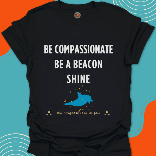 Black t-shirt with white motivational text "Be compassionate, be a beacon, shine"and blue dolphin swimming in the ocean graphic