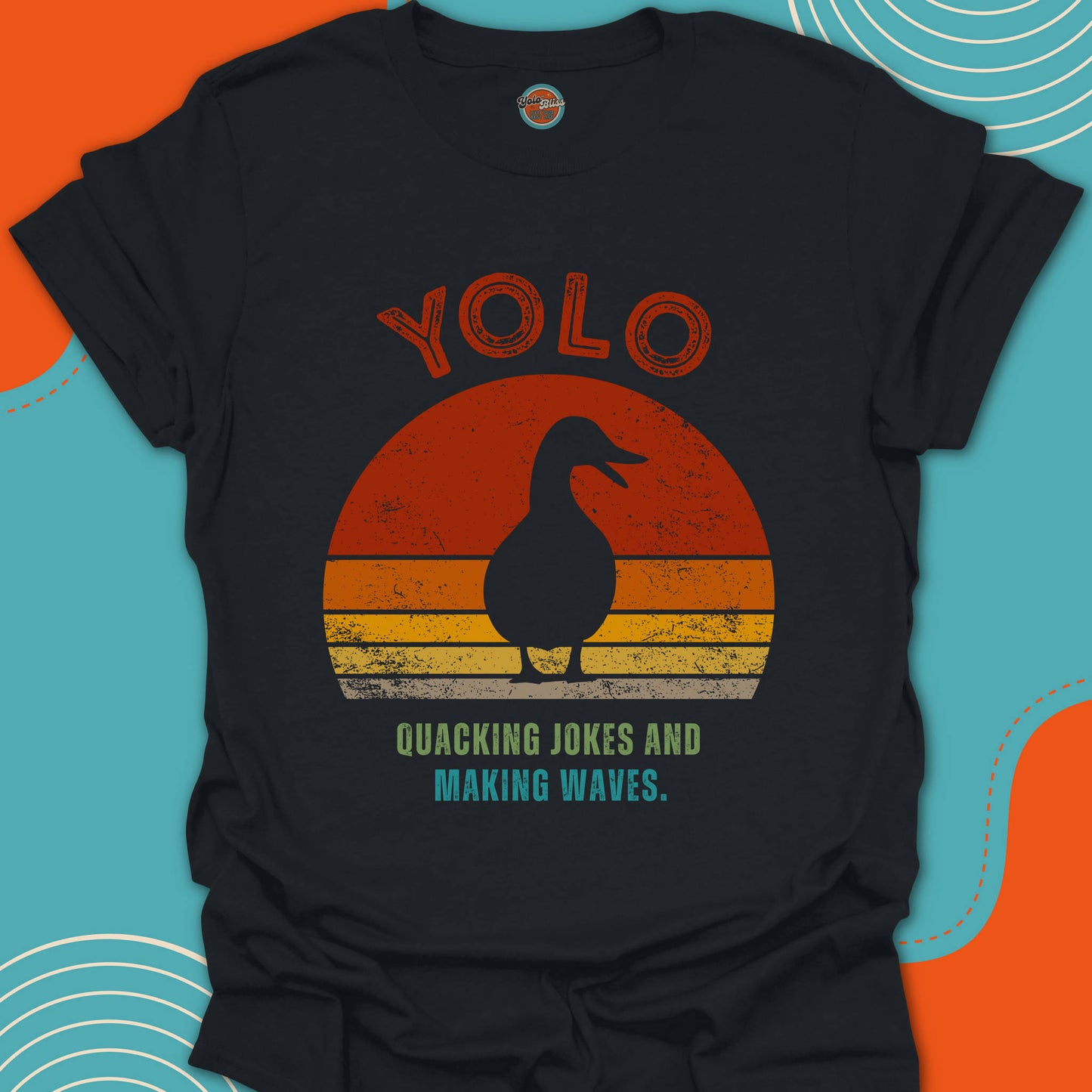Black t-shirt with a duck silhouette graphic and quacking jokes making waves text on an setting sun background