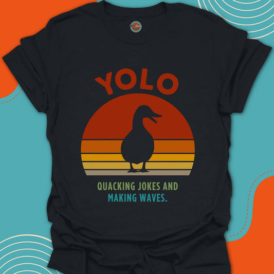 Black t-shirt with a duck silouhette graphic and "quacking jokes and making waves" text on a beautiful sunset background