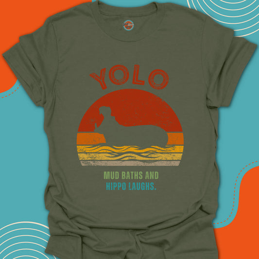 Green t-shirt with 'YOLO Mud Baths Hippo Laughs' text and cool hippopotamus graphic design on a trendy round sunset background