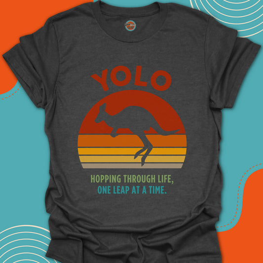 Dark gray t-shirt with jumping kangaroo graphic and 'YOLO hopping through life one leap at a time' text on a colorful sunset background
